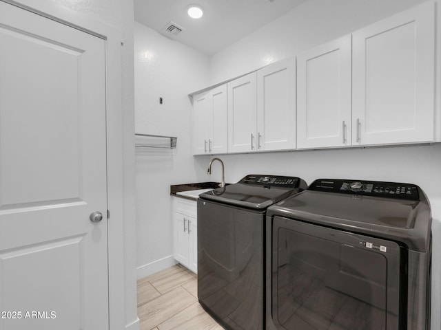 2395 S Polaris Way, Flagstaff, AZ 86001 - laundry room with washer and clothes dryer, cabinet space, light wood-style floors, and baseboards