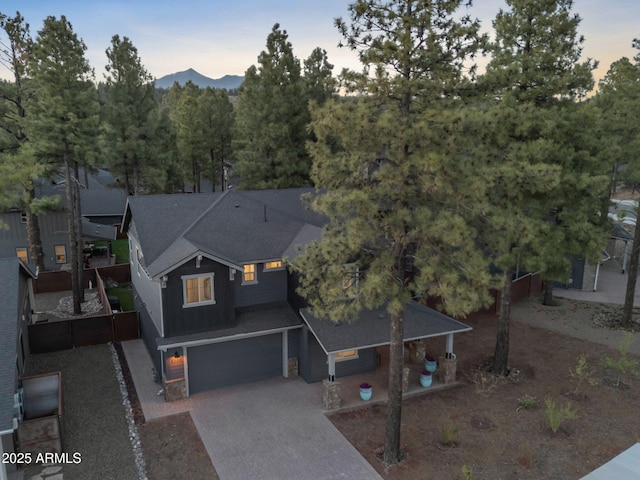 2395 S Polaris Way, Flagstaff, AZ 86001 - view of front of house featuring a garage, driveway, a shingled roof, a mountain view, and board and batten siding