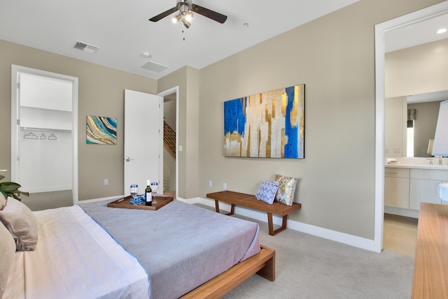 carpeted bedroom featuring ensuite bathroom, ceiling fan, and sink