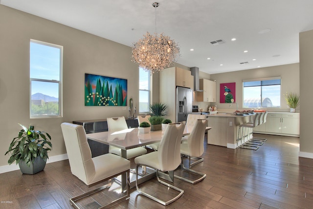 dining room featuring an inviting chandelier, sink, and dark wood-type flooring