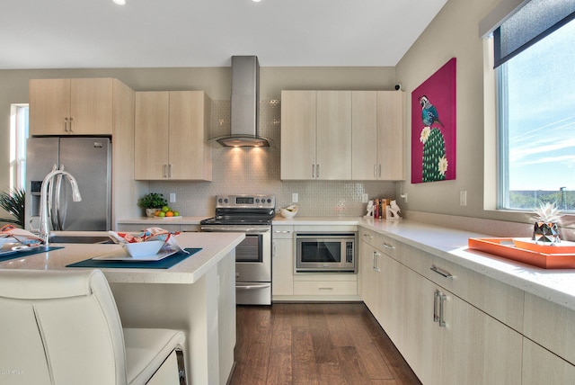 kitchen featuring dark hardwood / wood-style flooring, light brown cabinetry, stainless steel appliances, wall chimney exhaust hood, and backsplash