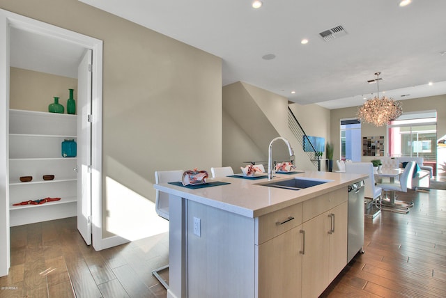 kitchen with decorative light fixtures, an inviting chandelier, a center island with sink, wood-type flooring, and sink