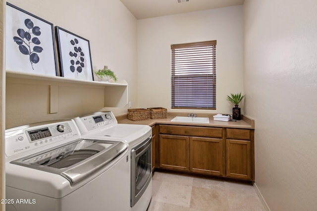 laundry room featuring washer and dryer, cabinet space, and a sink