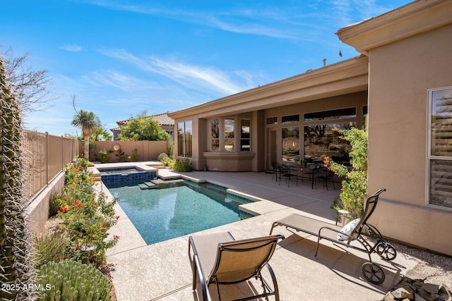 view of swimming pool featuring a fenced backyard, a pool with connected hot tub, and a patio