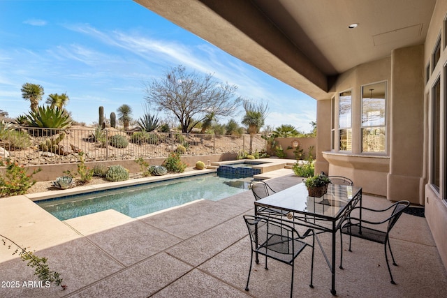 view of swimming pool featuring a pool with connected hot tub, a patio area, and a fenced backyard