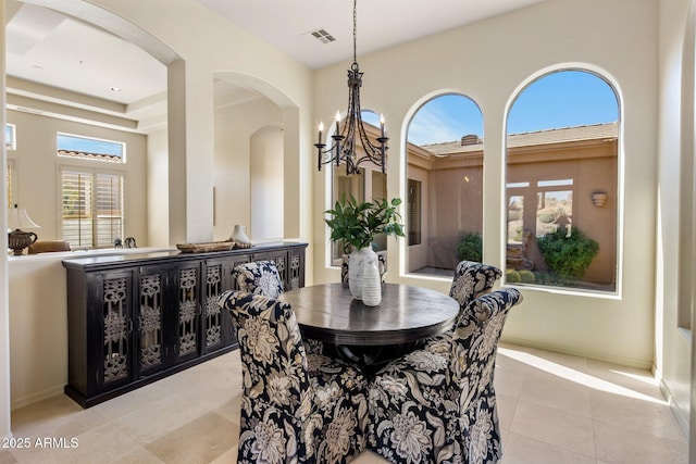 dining room featuring a chandelier, light tile patterned floors, arched walkways, and visible vents