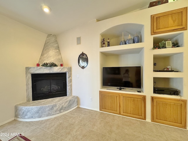 unfurnished living room featuring a fireplace, light tile patterned floors, and built in features