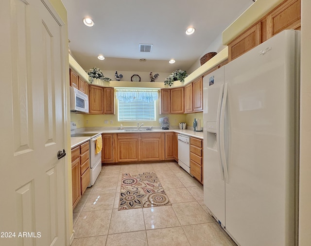 kitchen featuring sink, light tile patterned floors, and white appliances