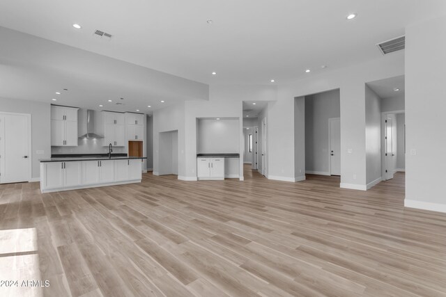 unfurnished living room featuring light hardwood / wood-style flooring and sink