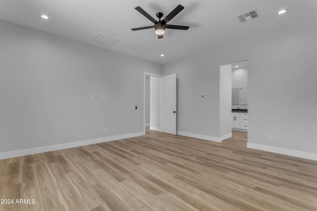 unfurnished bedroom featuring light hardwood / wood-style floors, ceiling fan, and connected bathroom