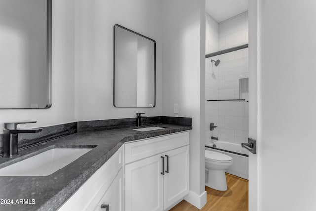 full bathroom featuring hardwood / wood-style floors, enclosed tub / shower combo, toilet, and vanity