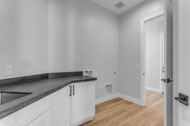 laundry room featuring cabinets, light hardwood / wood-style floors, hookup for a washing machine, and hookup for an electric dryer