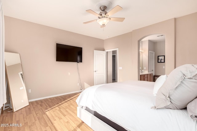 bedroom featuring ceiling fan, light wood-type flooring, and ensuite bath