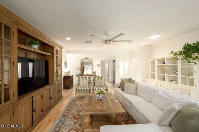 living room featuring ornamental molding, ceiling fan, and light wood-type flooring