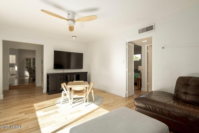 living room with light wood-type flooring and ceiling fan