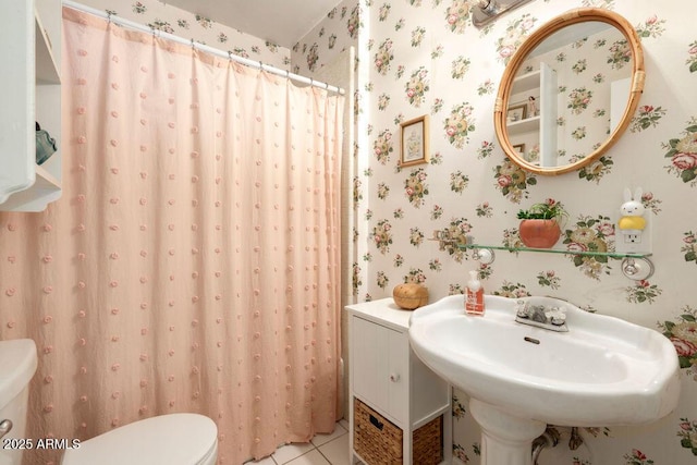 bathroom featuring toilet, tile patterned flooring, and sink