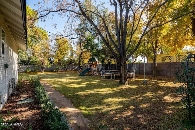 view of yard featuring a playground and a trampoline