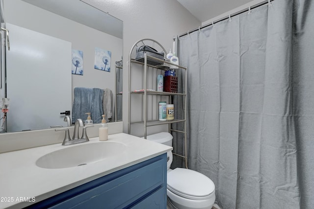 bathroom with vanity, curtained shower, and toilet