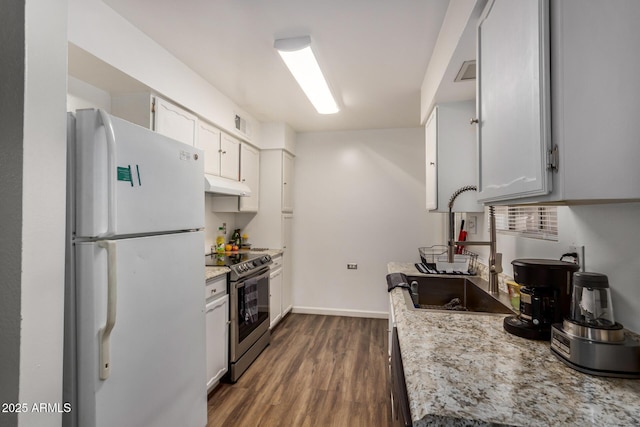 kitchen featuring baseboards, electric stove, dark wood-type flooring, freestanding refrigerator, and under cabinet range hood