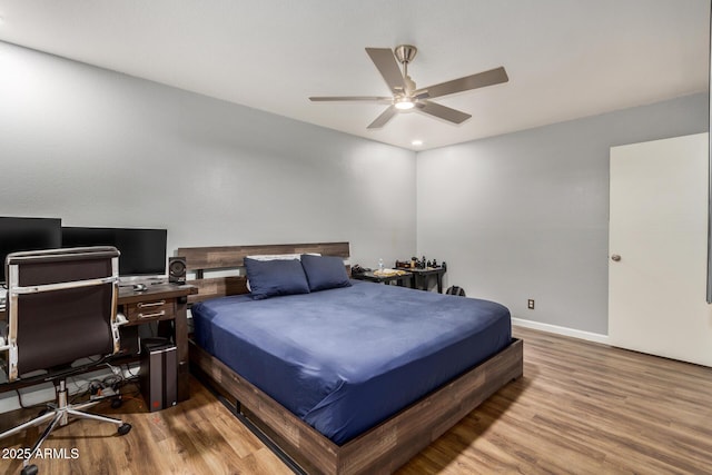 bedroom featuring wood finished floors, a ceiling fan, and baseboards