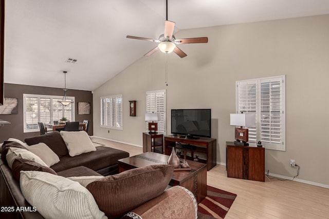 living room with high vaulted ceiling, ceiling fan, and light wood-type flooring