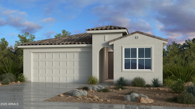 mediterranean / spanish-style house featuring stucco siding, driveway, an attached garage, and a tiled roof