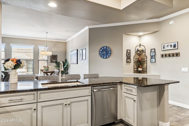 kitchen with stainless steel dishwasher, a sink, dark stone counters, decorative light fixtures, and ornamental molding