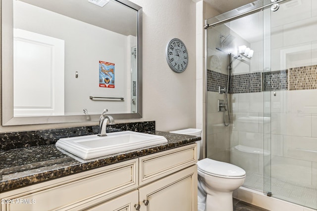 full bathroom featuring visible vents, vanity, a shower stall, and toilet