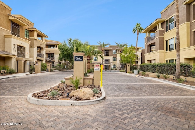 view of street with a gated entry, a residential view, and curbs