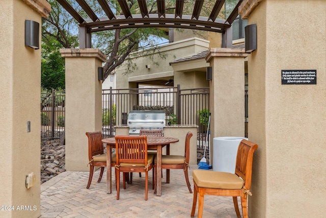 view of patio with a pergola, outdoor dining space, grilling area, fence, and an outdoor kitchen