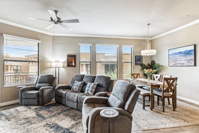 living area featuring ceiling fan, baseboards, crown molding, and wood finished floors