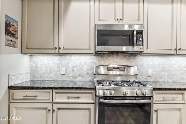 kitchen featuring stainless steel appliances, backsplash, and cream cabinetry