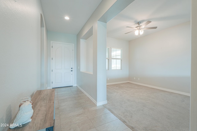 foyer entrance featuring ceiling fan and light colored carpet