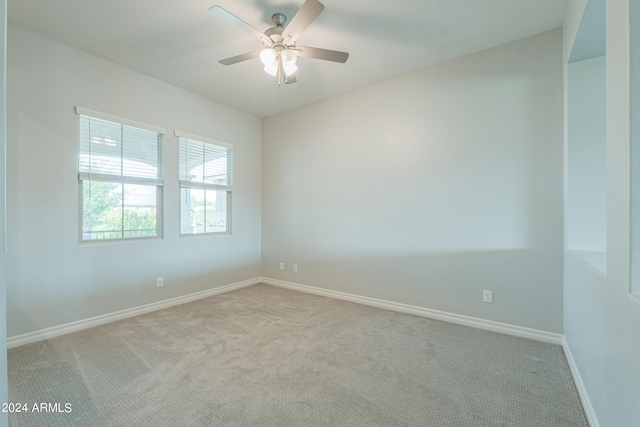 empty room featuring ceiling fan and light colored carpet