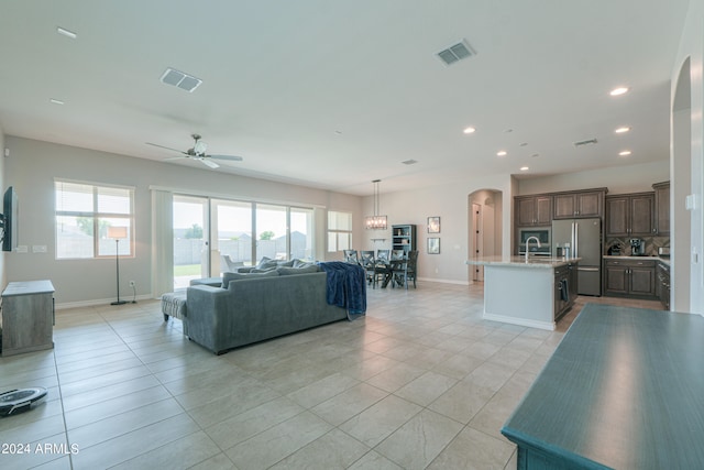 tiled living room with ceiling fan and sink