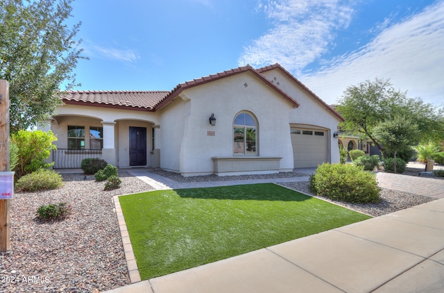 mediterranean / spanish-style house with a front lawn and a garage