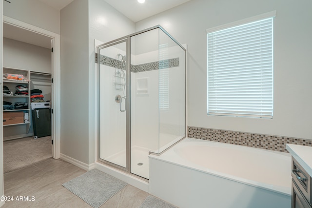 bathroom featuring shower with separate bathtub, tile patterned floors, and vanity