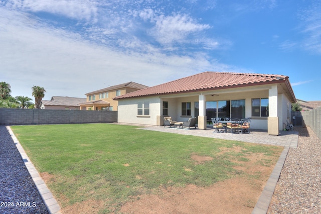 rear view of house with a lawn, outdoor lounge area, and a patio area