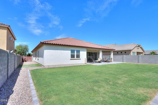 back of house featuring a lawn and a patio