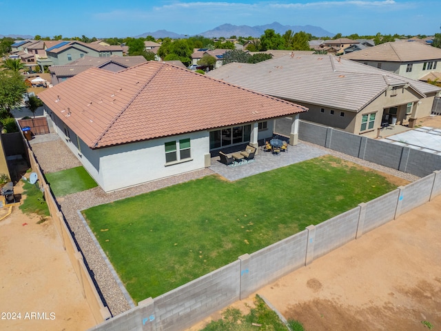 view of front facade featuring a front lawn, a mountain view, and a patio area