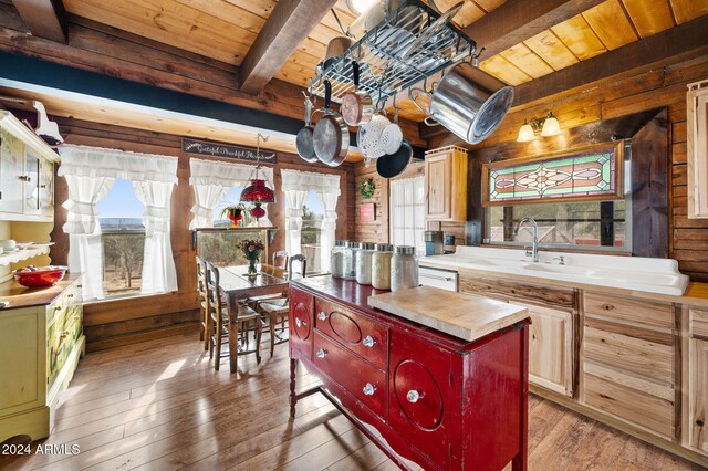 kitchen featuring wooden walls, plenty of natural light, and wood-type flooring