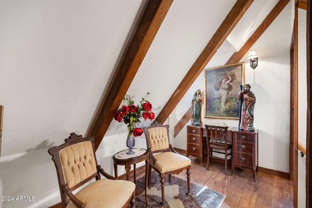 sitting room featuring dark hardwood / wood-style flooring and lofted ceiling with beams