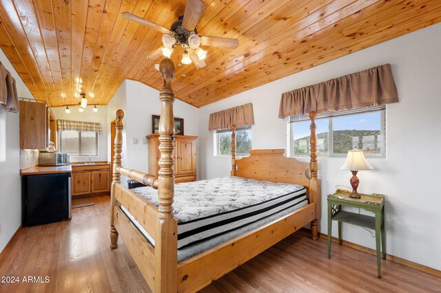 bedroom with sink, vaulted ceiling, ceiling fan, light hardwood / wood-style floors, and wood ceiling