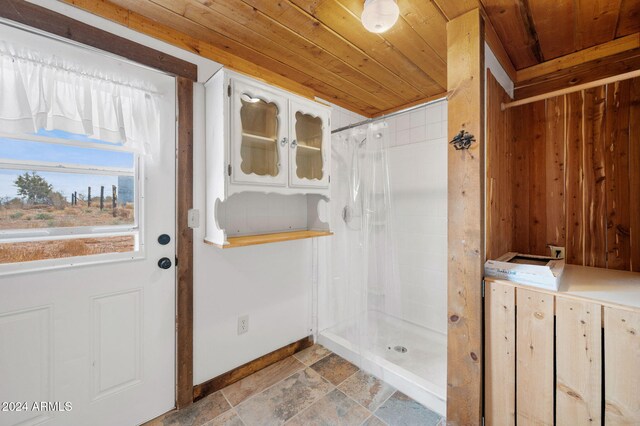 bathroom featuring walk in shower and wooden ceiling