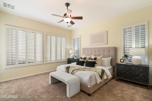 carpeted bedroom featuring ceiling fan and multiple windows