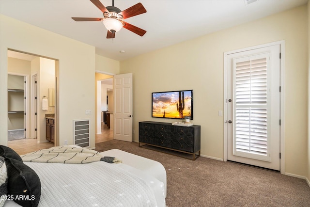 carpeted bedroom with ceiling fan and ensuite bath