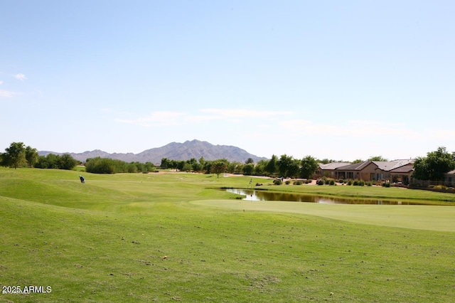 view of home's community with a water and mountain view and a lawn