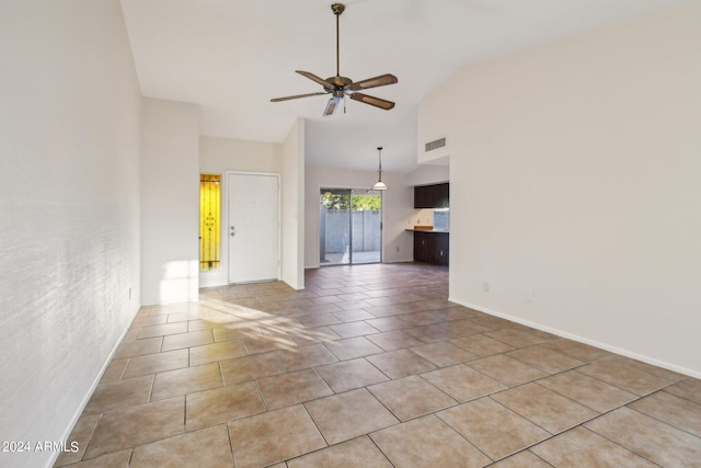 spare room with ceiling fan, high vaulted ceiling, and light tile patterned floors