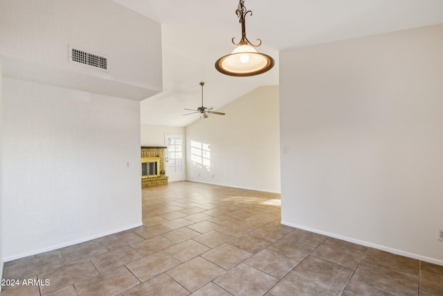 unfurnished room with a fireplace, light tile patterned flooring, ceiling fan, and vaulted ceiling