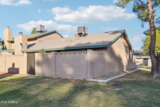 view of side of property with a yard and cooling unit